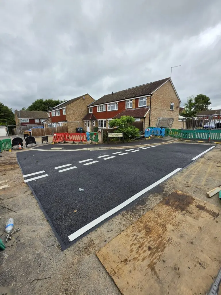 Housing estate junction resurfaced in tarmac, with new road markings